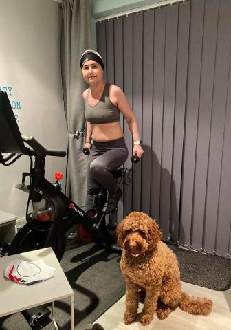 Ellissa on her bike with her dog next to her